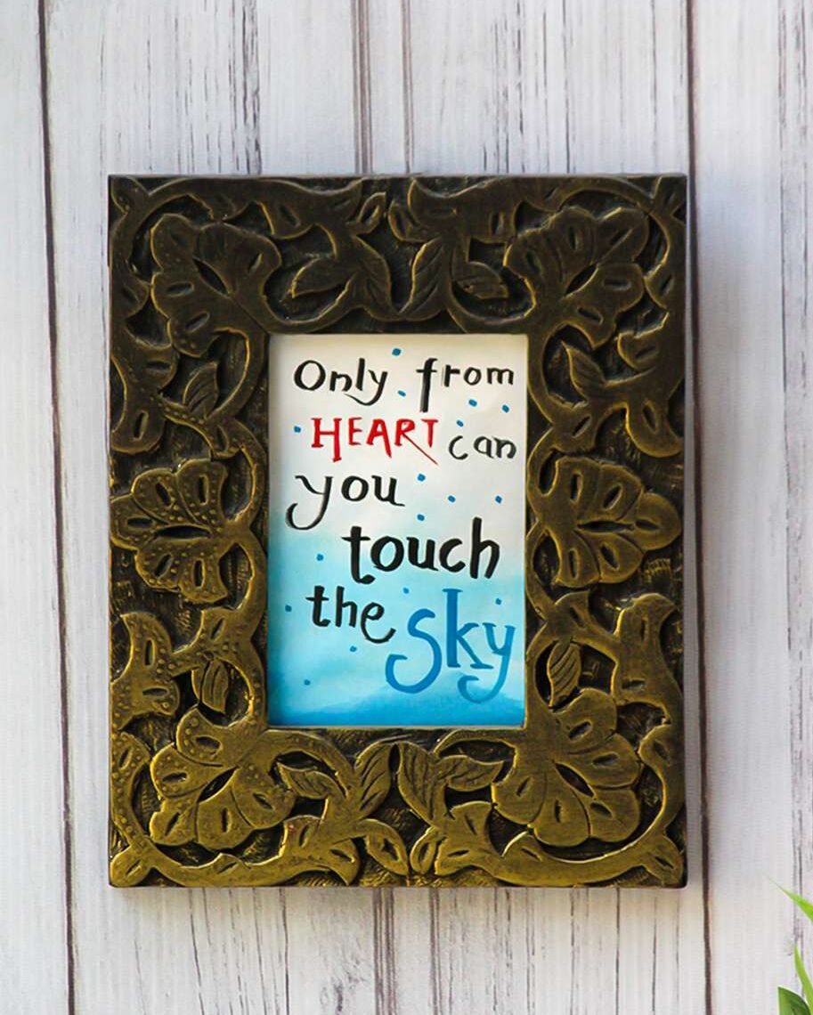 antique wood frame with leaf patterns surrounds a motivational quote in mixed fonts on a blue-gradient background.