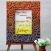 A handmade photo frame with floral carvings in red, gold, and blue hues. Inside, conveying a motivational message.