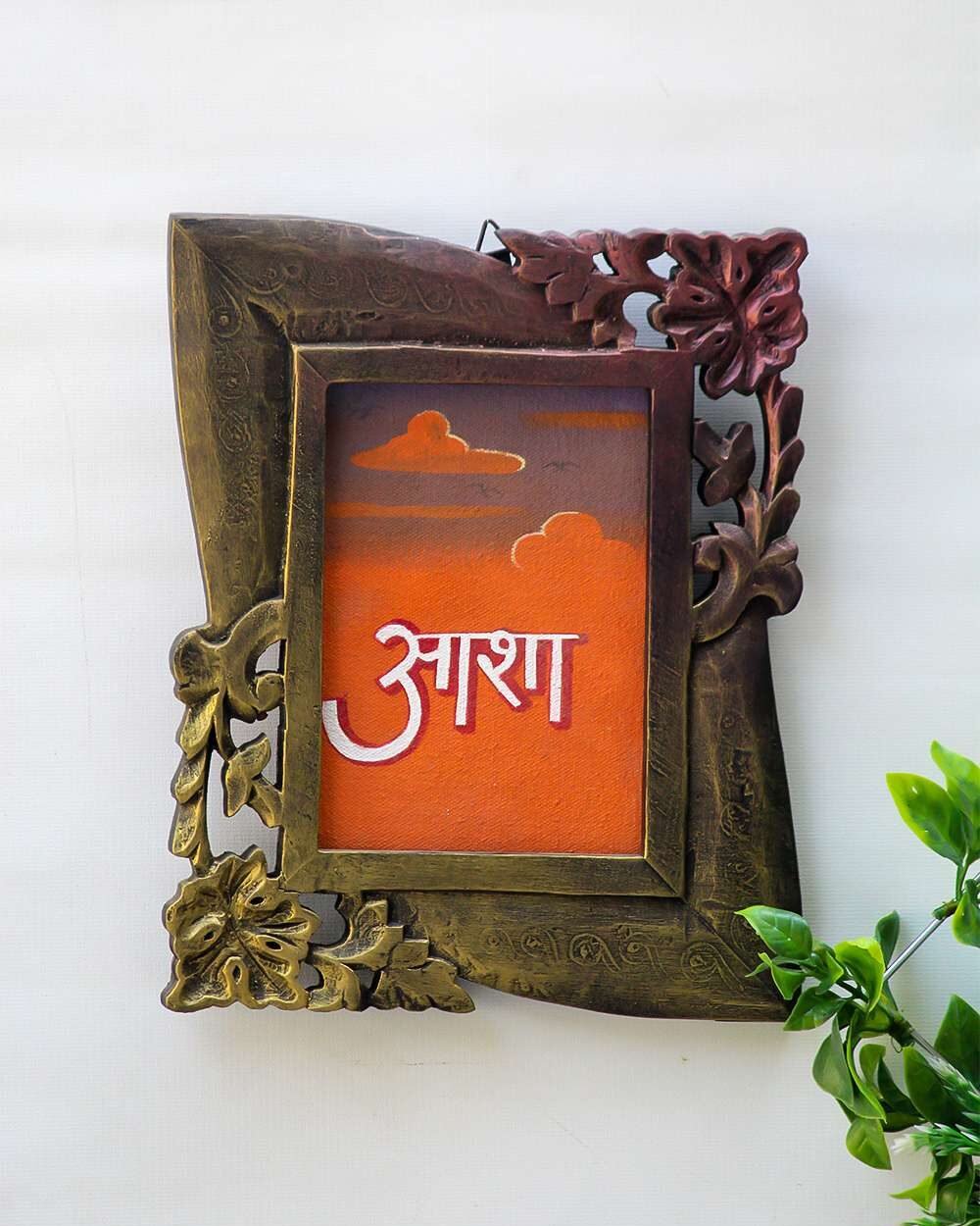 wooden family photo frame with floral accents surrounds an orange canvas featuring Hindi script and clouds. Bright and hopeful mood.