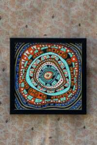 Abstract & modern painting with concentric circles in orange, blue, and turquoise patterns. Features geometric shapes with a black frame.