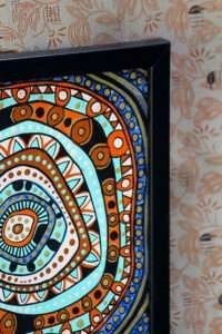Abstract painting with concentric circles in vibrant orange, blue, and turquoise tones, framed in black, creating a bold, energetic pattern.