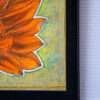 Close-up of a framed painting showing part of a bright orange flower with pointed petals on a textured, speckled green and yellow background.