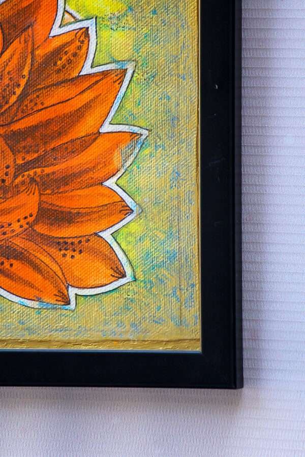 Close-up of a framed painting showing part of a bright orange flower with pointed petals on a textured, speckled green and yellow background.