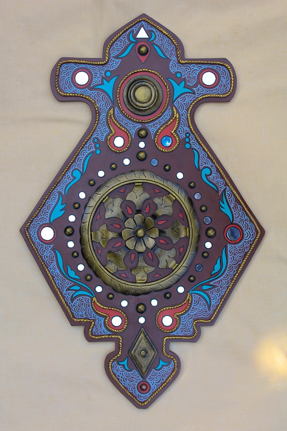 Ornate purple and blue wall decoration with symmetrical floral patterns and circular designs. Central circular floral motif, evoking classic elegance.