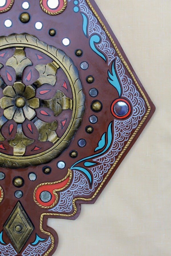 Intricate decorative wooden panel with floral and geometric patterns, featuring gold, red, black, and blue accents on a beige background. Ornate and elegant.