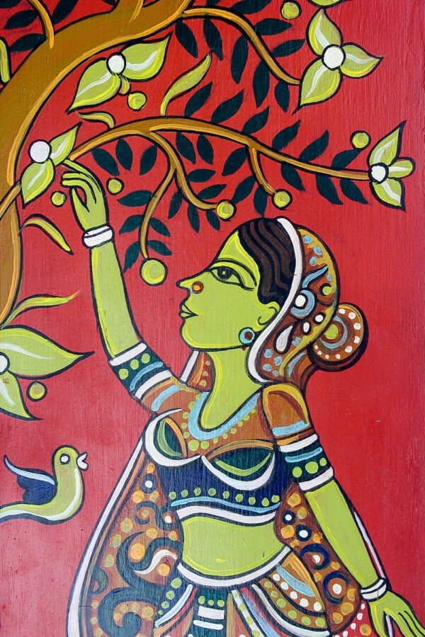 Colorful painted wall hanging of a woman with green skin reaching for a tree branch adorned with white flowers. A bird sits nearby. Vibrant and joyful tone.